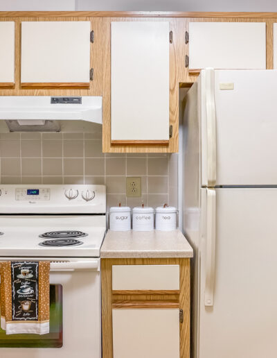 Kitchen Featuring Lower & Upper Cabinets With Fridge